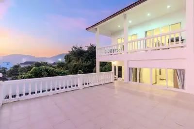 a large white house with a balcony with a sunset at V274 Prime Location Large Terrace Pool View BBQ in Ban Saiyuan (1)