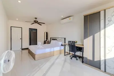 a bedroom with a bed and a desk with a fan at V274 Prime Location Large Terrace Pool View BBQ in Ban Saiyuan (1)