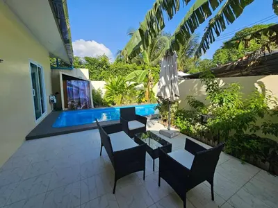 a patio with a table and chairs and a pool at 2 Bedrooms Tropical Pool Villa Rawai in Rawai Beach