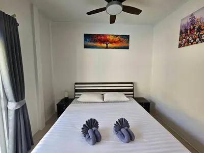 a bedroom with a bed with a ceiling fan at 2 Bedrooms Tropical Pool Villa Rawai in Rawai Beach