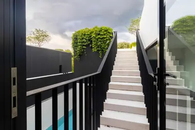 a staircase with plants on a black fence at V275 Stay with Nature 2BR Peaceful Pool Villa in Ban Pak Lak
