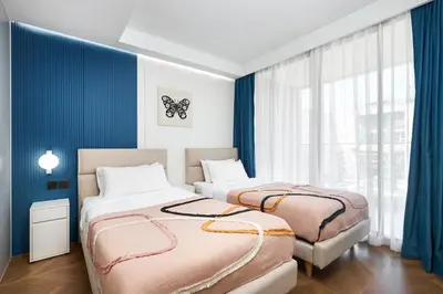 two beds in a room with blue walls at Sunshine Beach Bang Tao by My Home Phuket in Layan Beach
