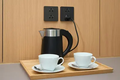 a coffee maker and two cups on a wooden tray at Sunshine Beach Bang Tao by My Home Phuket in Layan Beach