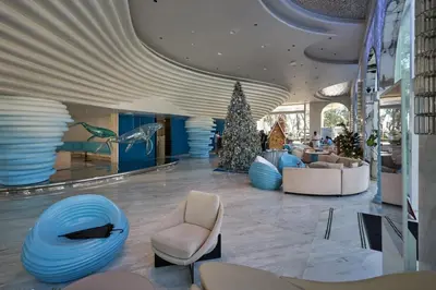 a lobby with chairs and a christmas tree in a building at Sunshine Beach Bang Tao by My Home Phuket in Layan Beach