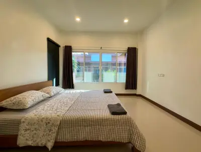 a bedroom with a large bed with a window at Sea sand Bungalow in Phuket Town