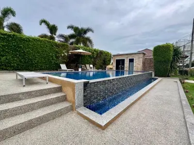 a swimming pool with a bench next to a house at Sea sand Bungalow in Phuket Town