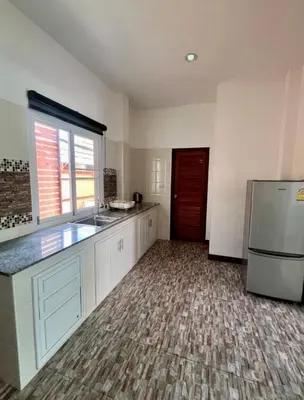 a kitchen with white cabinets and a refrigerator at Sea sand Bungalow in Phuket Town