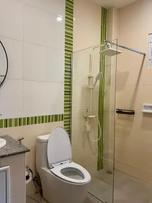 a bathroom with a toilet and a glass shower at Sea sand Bungalow in Phuket Town