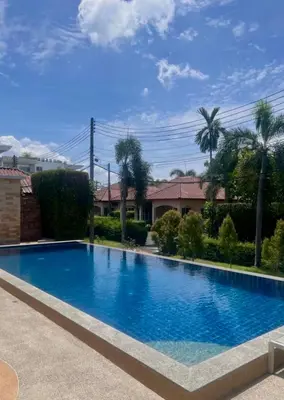 a large blue swimming pool in front of a house at Sea sand Bungalow in Phuket Town