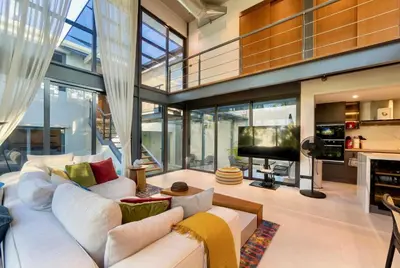 a living room with a white couch and a tv at RIVERHOUSE Solar-Powered Luxury Pool Villas in Laguna Phuket