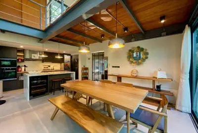 a dining room with a wooden table and benches at RIVERHOUSE Solar-Powered Luxury Pool Villas in Laguna Phuket