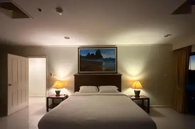 a bedroom with a large bed and two tables with lamps at Highest Apartment in Phuket Panaromic Seaview in Patong Beach