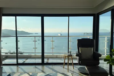 a living room with a chair and a view of the ocean at Highest Apartment in Phuket Panaromic Seaview in Patong Beach