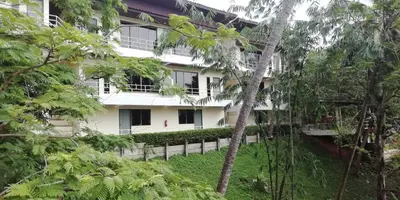 a white building with trees in front of it at Baan-kawkaew-kata in Karon Beach