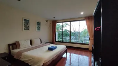 a bedroom with a large bed and a large window at Baan-kawkaew-kata in Karon Beach