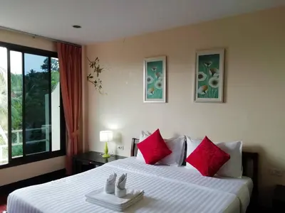 a bedroom with a large bed with red pillows at Baan-kawkaew-kata in Karon Beach