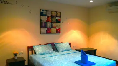 a bedroom with a bed and a painting on the wall at Baan-kawkaew-kata in Karon Beach
