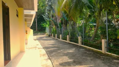 a sidewalk next to a fence with palm trees at Baan-kawkaew-kata in Karon Beach