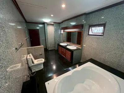 a bathroom with a tub and two sinks and a toilet at Villa Vasu in Ban Bang Khu