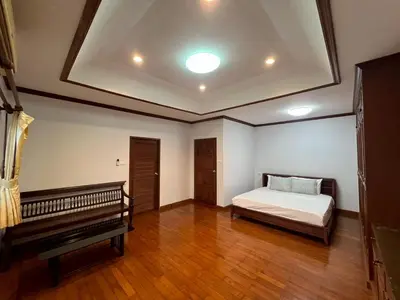 a bedroom with a bed and a bench in it at Villa Vasu in Ban Bang Khu