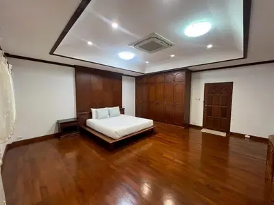 a bedroom with a bed and a wooden floor at Villa Vasu in Ban Bang Khu