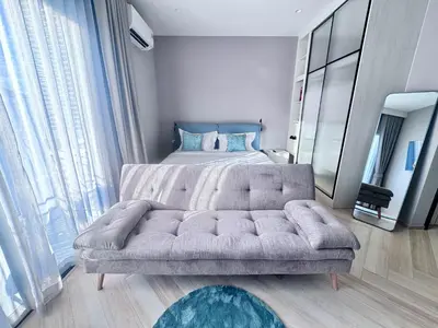 a bedroom with a couch in front of a bed at Title Ledgendary 7th Floor in Bang Tao Beach