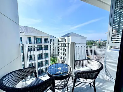 a balcony with two chairs and a table on a balcony at Title Ledgendary 7th Floor in Bang Tao Beach