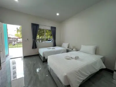 a bedroom with two beds and a window at Karon Little House in Karon Beach