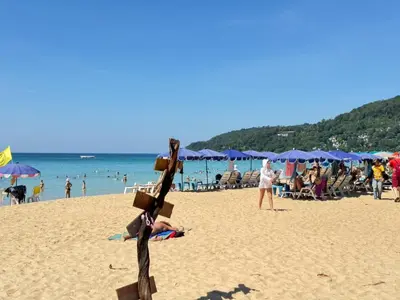 a sculpture on a beach with people in the water at Karon Little House in Karon Beach