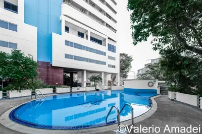 a swimming pool in front of a building at OMNIAPhuket - Sea View Patong Tower 100m to Beach in Patong Beach