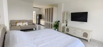 a white bedroom with a bed and a flat screen tv at patong sea view-high floor in Patong Beach
