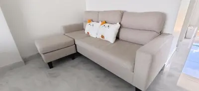 a couch with three pillows on it in a room at patong sea view-high floor in Patong Beach