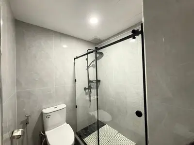 a bathroom with a toilet and a glass shower at patong sea view-high floor in Patong Beach