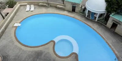 an overhead view of a large swimming pool with two white chairs at patong sea view-high floor in Patong Beach
