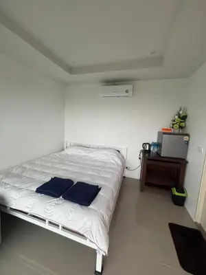 a bedroom with a bed with two blue pillows on it at Mong Do Lay Baan Sea View in Ban Ao Makham