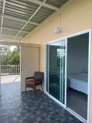 a room with a bed and a chair on a patio at Mong Do Lay Baan Sea View in Ban Ao Makham