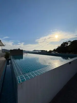 a swimming pool with the sun setting in the background at 3 Beds patong baycleef residence in Patong Beach