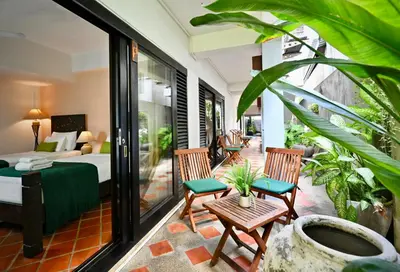 a room with a bed and two chairs on a patio at PapaCrab Boutique Guesthouse in Kamala Beach
