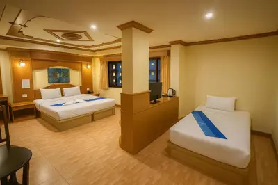 a hotel room with two beds and a television at Tiger Complex Inn in Patong Beach