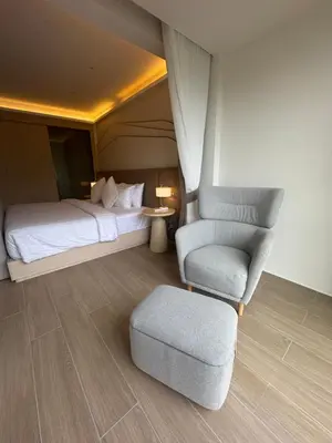 a bedroom with a bed and a chair and a couch at Apartment Wyndham Naithon in Nai Thon Beach