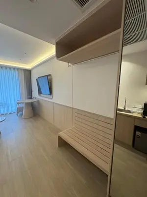 a living room with a bench and a television at Apartment Wyndham Naithon in Nai Thon Beach