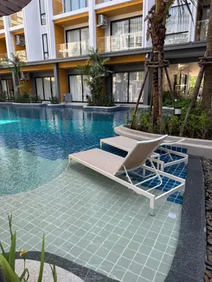a lounge chair sitting next to a swimming pool at Apartment Wyndham Naithon in Nai Thon Beach