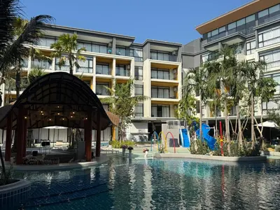 a swimming pool in front of a building at Apartment Wyndham Naithon in Nai Thon Beach