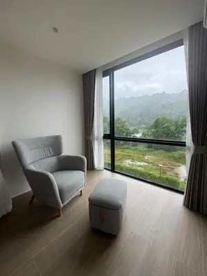 a living room with a couch and a large window at Apartment Wyndham Naithon in Nai Thon Beach