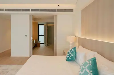 a bedroom with a large white bed with blue pillows at Villa Belle Air Panwa Beachfront 6BR Breakfast included in Ban Ao Makham