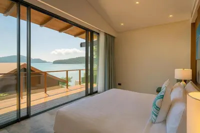 a bedroom with a bed and a view of the ocean at Villa Belle Air Panwa Beachfront 6BR Breakfast included in Ban Ao Makham