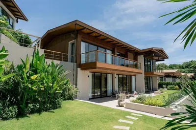 a house with a balcony with a yard at Villa Belle Air Panwa Beachfront 6BR Breakfast included in Ban Ao Makham