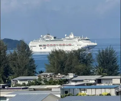 a large cruise ship in the water with trees at patong sea view-high floor in Patong Beach