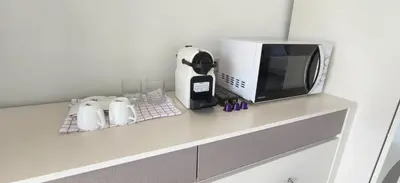 a counter with a microwave and a coffee maker at patong sea view-high floor in Patong Beach