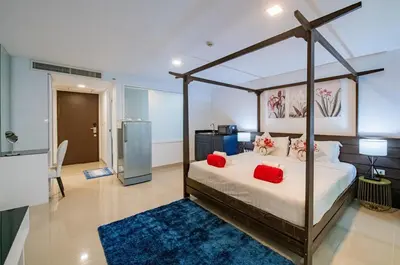 a bedroom with a canopy bed with red pillows at the Kris Bangtao Phuket not in laguna area in Laguna Phuket